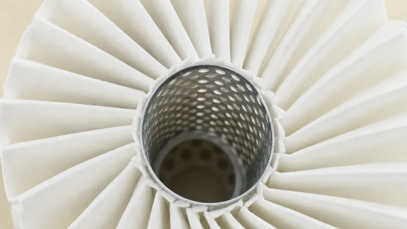 Close-up of pleated oil filter paper around a perforated metal centre tube